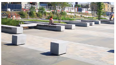 An image showing a paved open space with benches. 