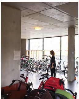 An image showing a communal indoor space with bicycles parked. 