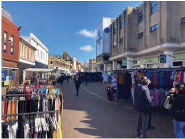 A view of the pedestrianised area of Midland Road. The shopping centre, other shops and the market line the pedestrian area.