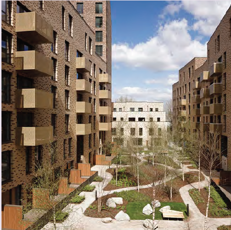 An image of high rise blocks of flats with balconies, with a communal green open space between them.