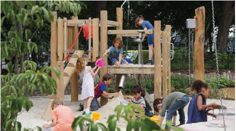 An image of children playing on wooden climbing frame equipment, with a play sand pit.