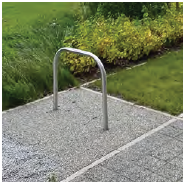 An image of a single bicycle rack that is adjacent to a pathway. 