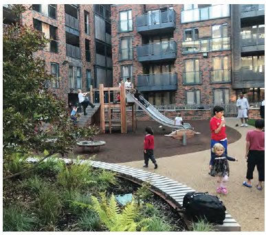 An image of an equipped play area in a communal open space which is surrounded by residential blocks.
