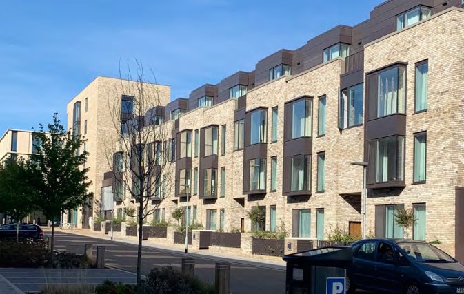 An image showing a modern residential housing development with uniform front gardens contributing to the street scene.